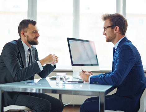 Business Meeting | CAQA Publications Two businessmen discuss strategy during a meeting, contributing to the development of effective vet training.