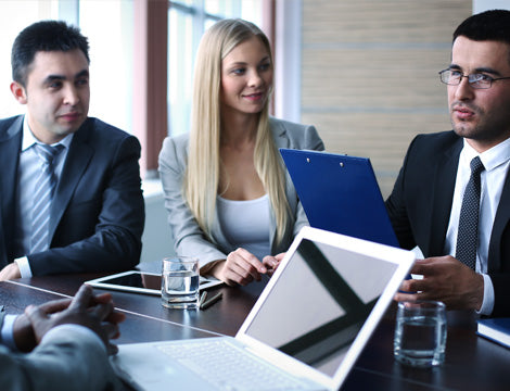 Business Meeting | CAQA Publications Business professionals discuss strategy around a conference table, demonstrating effective vet training practices.