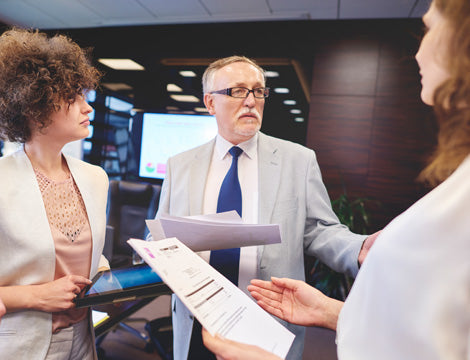 Business People | CAQA Publications Business professionals discuss documents, demonstrating the importance of quality vet training resources.