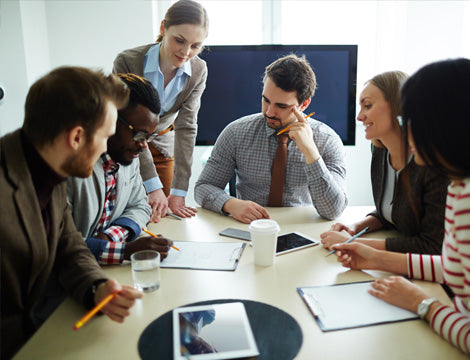 Diverse Team | CAQA Publications A diverse group collaborates around a table during a business meeting, showcasing effective teamwork for vet training.