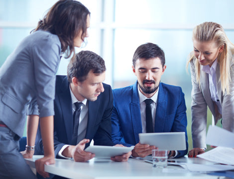 Financial Viability Risk Assessment | CAQA Publications A business team collaborates reviewing documents on tablets, demonstrating the importance of vet training resources.