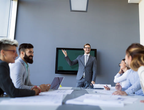 Office Presentation | CAQA Publications A businessman presents to a team during an office meeting, illustrating effective vet training techniques.