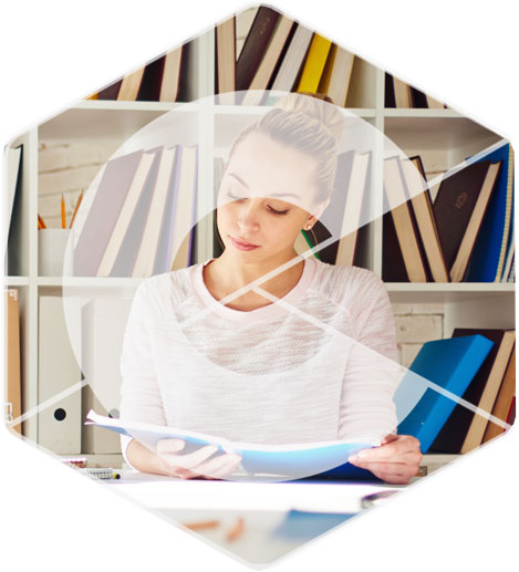 A woman reviews documents at a desk, showcasing vet training resources.